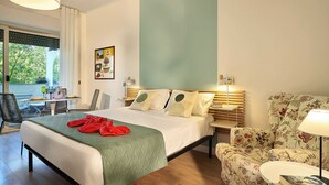 A hotel room with a bed, a chair, a table, and a lamp. - Cosy app, balcony, S. Peter's view, parking (Roma)