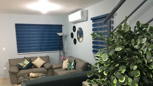 Ein Wohnzimmer mit einer Couch, einem Couchtisch und einer Treppe.