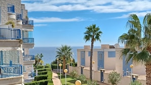A residential area with a pathway leading to a body of water, surrounded by buildings with balconies and palm trees. - Modern 2 slaapkamerappt met zwembad-jacuzzi, terras 1 sts lijn in afgesl. res. (Orhiuela-Costa)