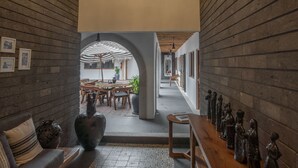 A hallway with a wooden bench, a chandelier, and a table with decorative items. - A Villa San Juan Bed & Breakfast (Nuevo Nayarit)