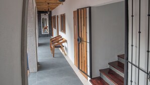A hallway with wooden beams, a staircase, and a bench. - A Villa San Juan Bed & Breakfast (Nuevo Nayarit)