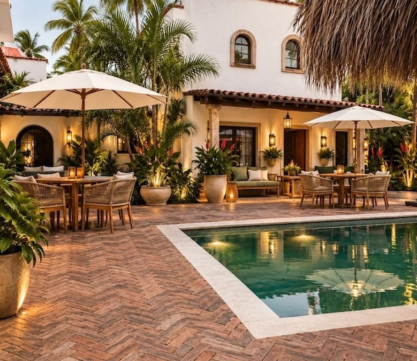 A poolside area with outdoor seating and a pool.