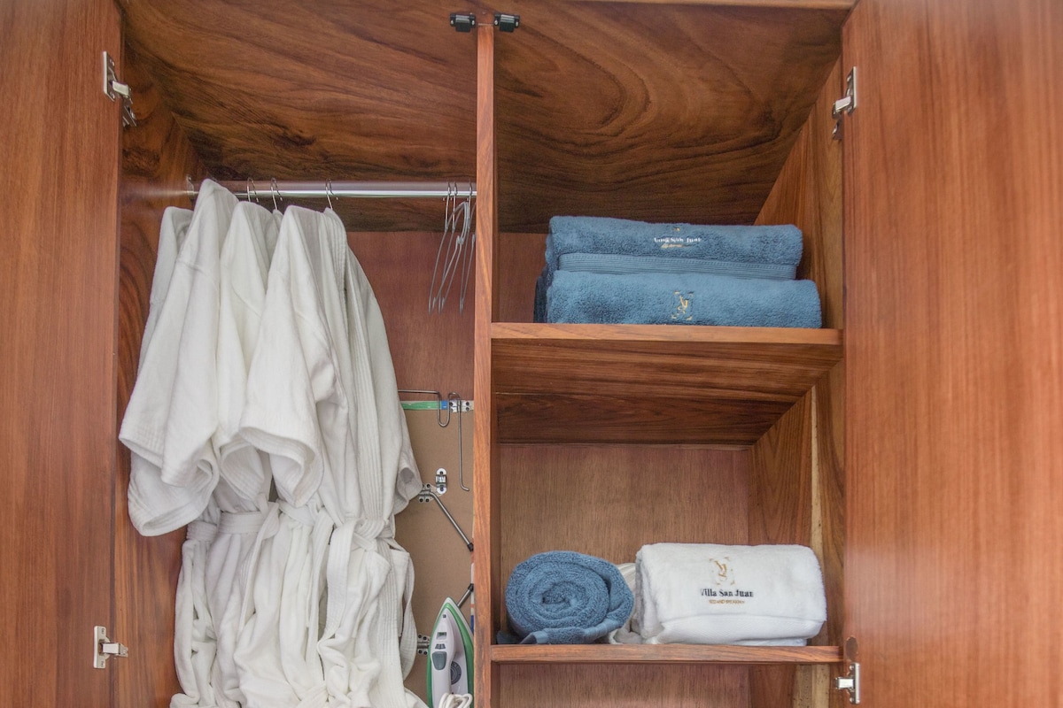 A wooden wardrobe with multiple compartments, including hanging space, shelves, and drawers.