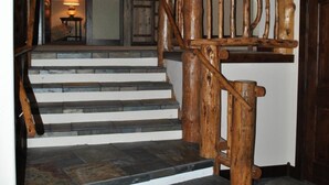 A wooden staircase with stone steps leading to a landing.