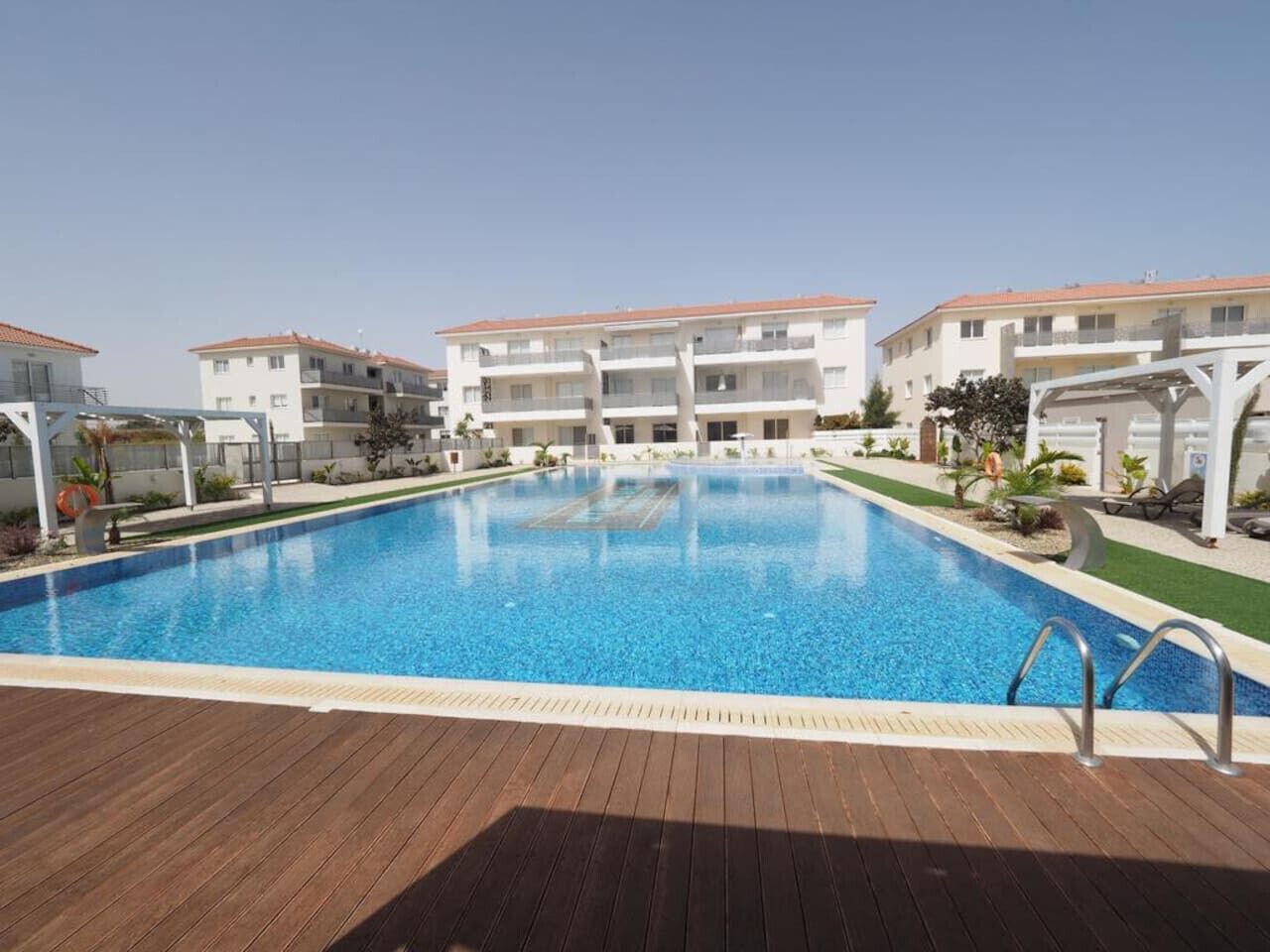 Une piscine entourée d’immeubles à plusieurs étages dotés de balcons.
