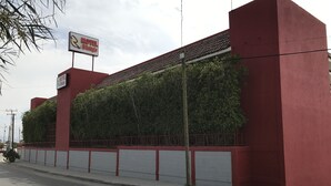 Un edificio rojo con un cartel que indica 'El Refugio', un motel.