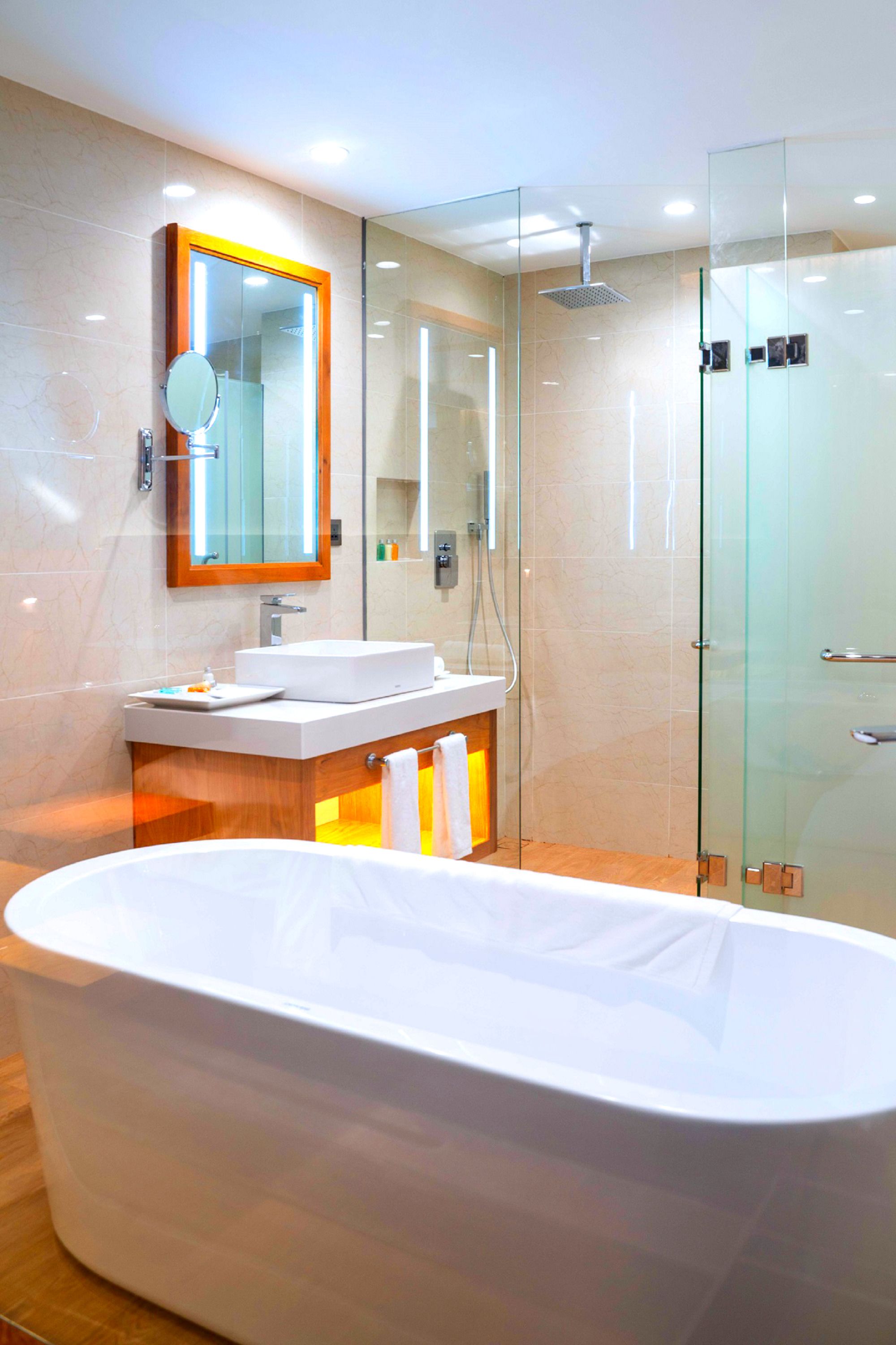A modern bathroom with a freestanding bathtub, a glass-enclosed shower, and a vanity with a mirror.
