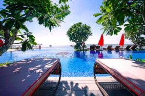 A pool area with lounge chairs and umbrellas, surrounded by tropical foliage. - Marina Bay Vung Tau Resort & Spa (Ho Chi Minh City)