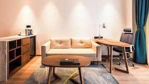 A modern room with a sofa, a desk, a chair, and a coffee machine. - NOVOTEL SUZHOU TAI LAKE SANTEH (SUZHOU)