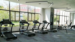 A gym with treadmills and exercise bikes, large windows, and a tiled floor. - NOVOTEL SUZHOU TAI LAKE SANTEH (SUZHOU)