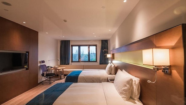A hotel room with two beds, a desk, a chair, and a TV. - NOVOTEL SUZHOU TAI LAKE SANTEH (SUZHOU)