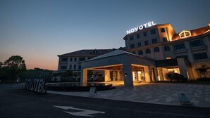 A Novotel hotel with a modern facade, large entrance, and illuminated signage. - NOVOTEL SUZHOU TAI LAKE SANTEH (SUZHOU)