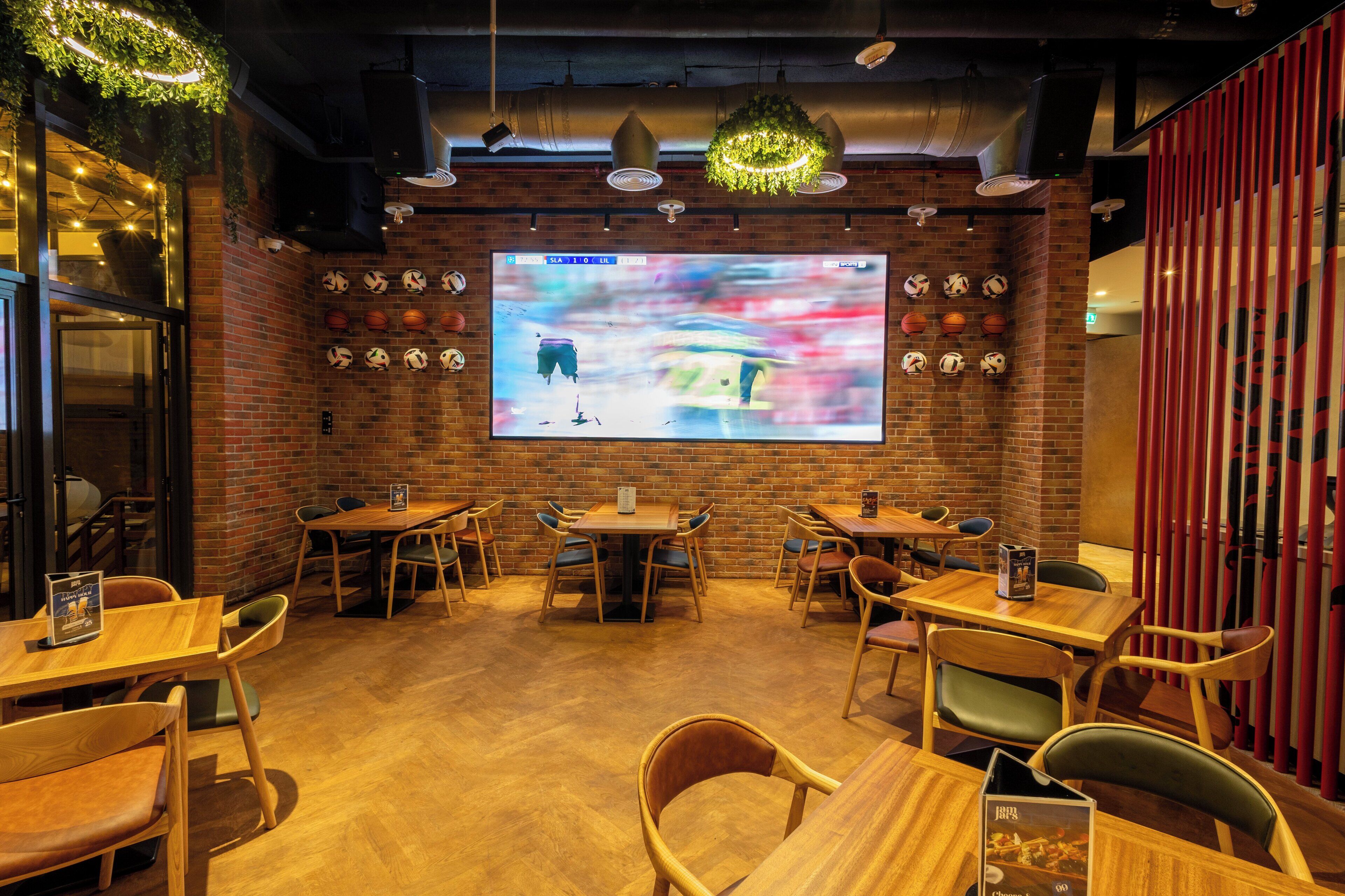 Un restaurant aux murs en briques, aux tables et aux chaises en bois.