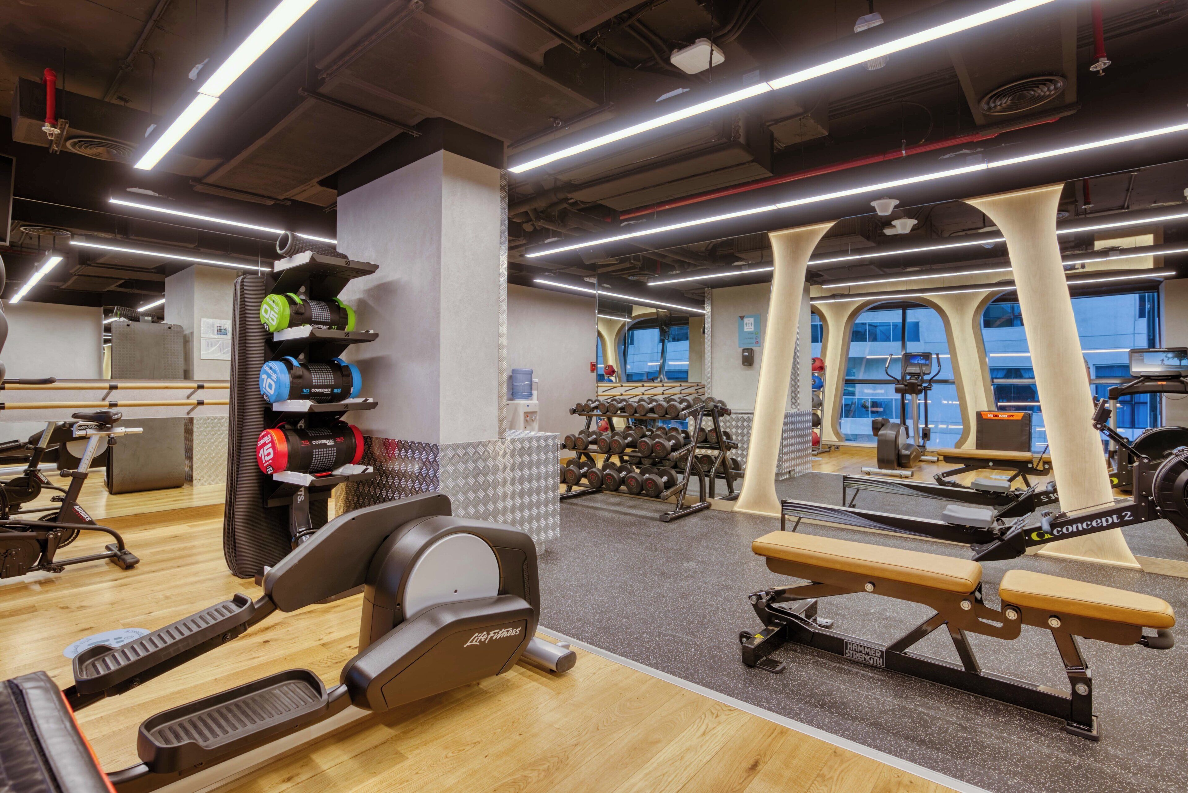 A gym with cardio equipment, weight machines, and dumbbells.