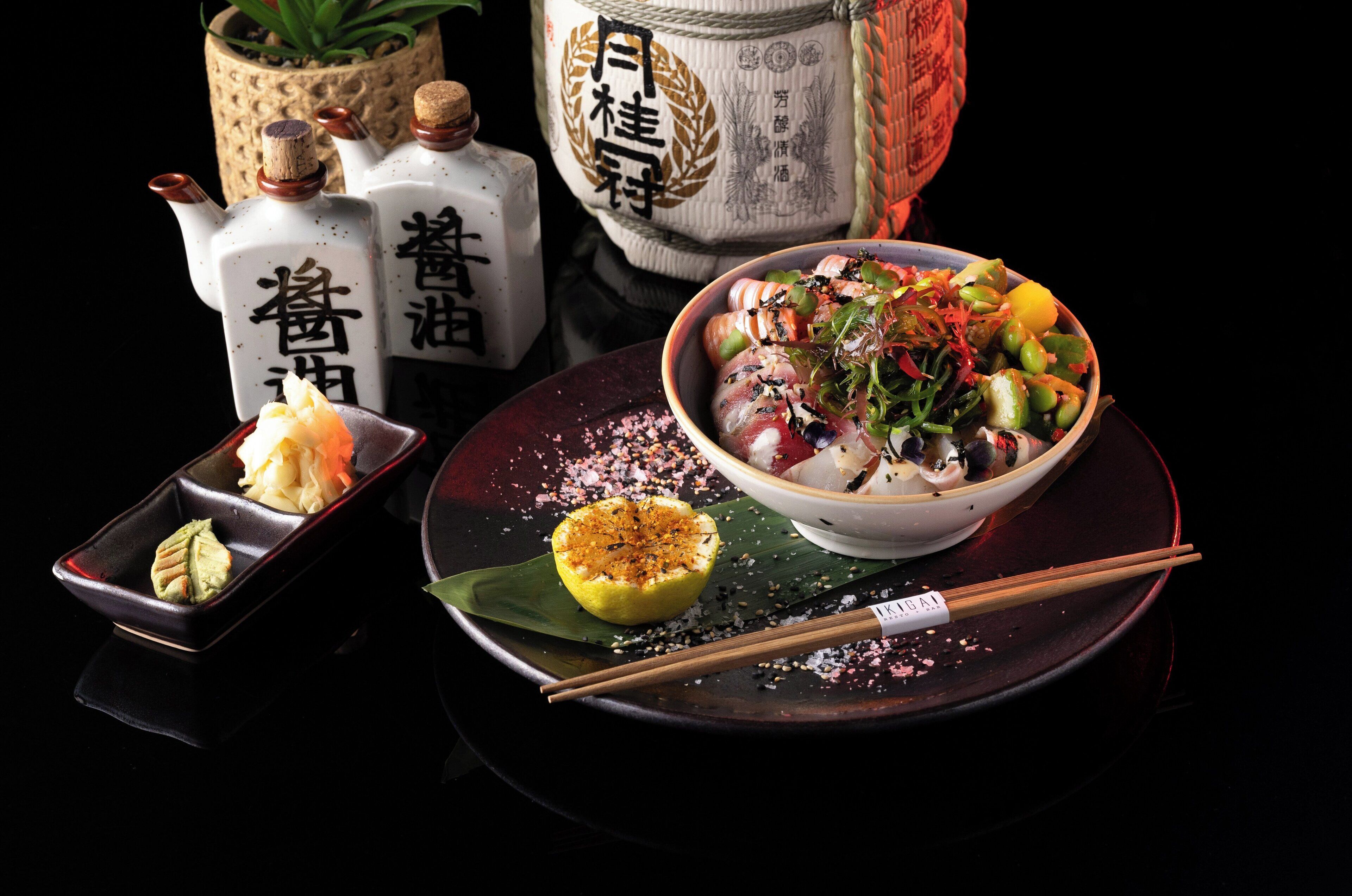 Un àpat tradicional japonès amb un bol de amanida, un plat petit de vegetals envinagrats i dues ampolles de salsa de soja.