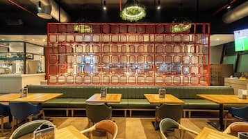 A restaurant interior with booths, tables, and a decorative red wall.