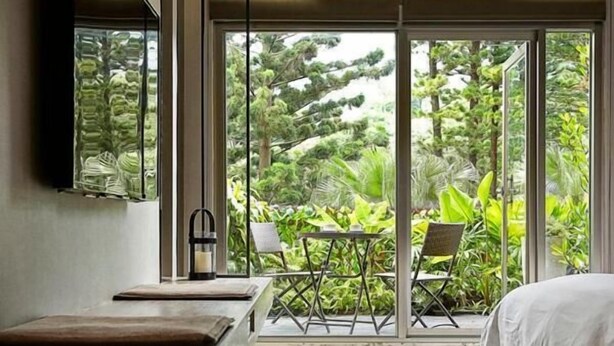 A modern bedroom with a large window, a bedside table, a bed, and a chair. - JBG Hotspring Resort Hotel (Taipei)