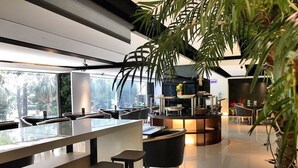 A modern bar area with high stools, a counter, and a seating area with tables and chairs. - JBG Hotspring Resort Hotel (Taipei)