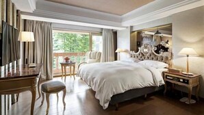 A hotel room with a large bed, a desk, a chair, and a small table. - JBG Hotspring Resort Hotel (Taipei)