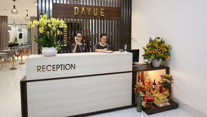 Una mesa de recepción con un letrero que dice "DAYUE" y "RECEPTORÍA".