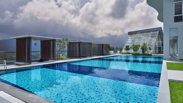 A modern outdoor swimming pool with a view of mountains and a cloudy sky. - Swiss-Garden Hotel & Residences, Genting Highlands (Genting Highlands)