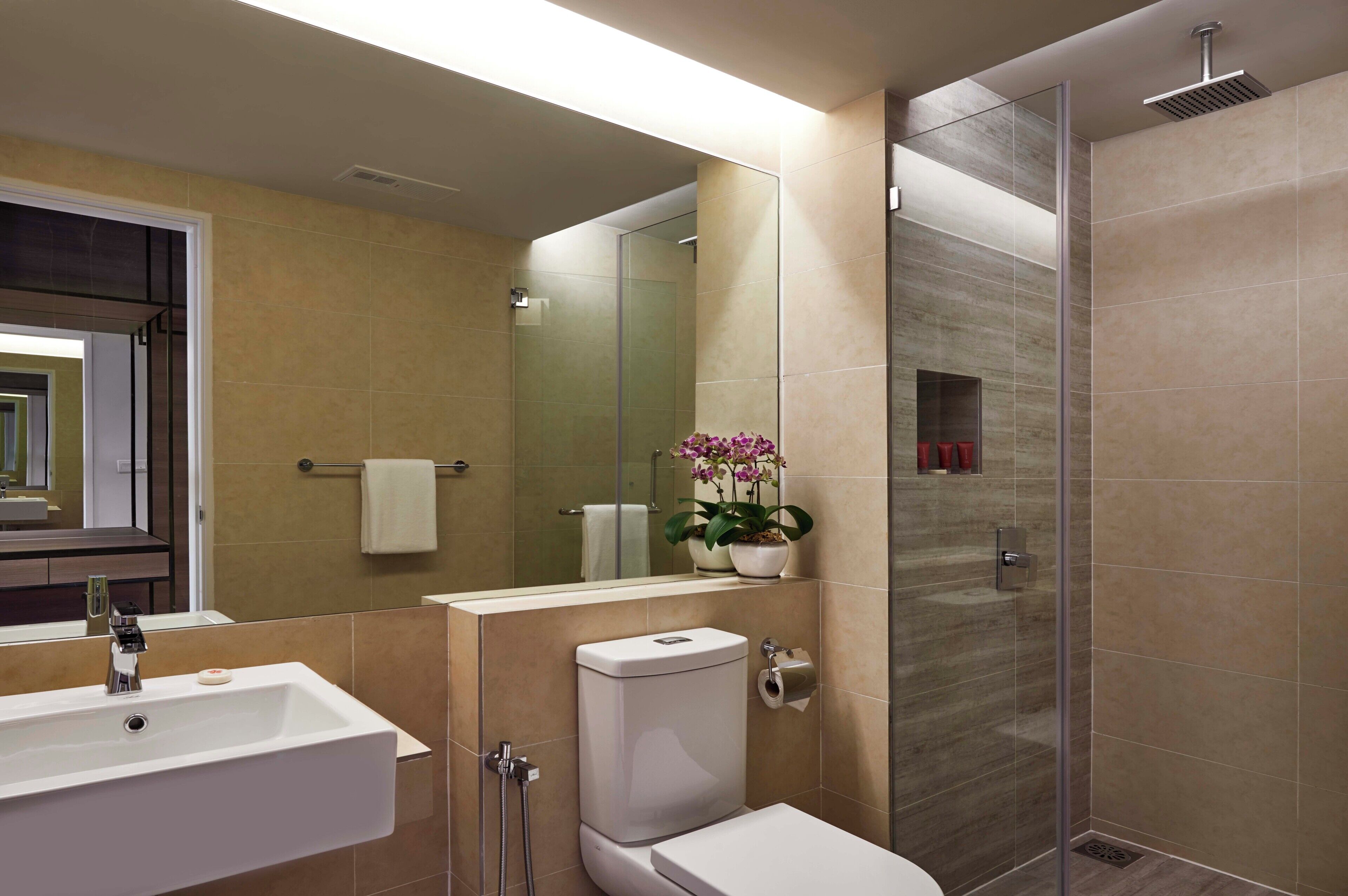 Un baño moderno con ducha, inodoro y lavamanos.