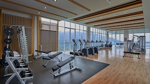 A modern gym with cardio machines, weightlifting equipment, and large windows offering a city view. - Swiss-Garden Hotel & Residences, Genting Highlands (Genting Highlands)