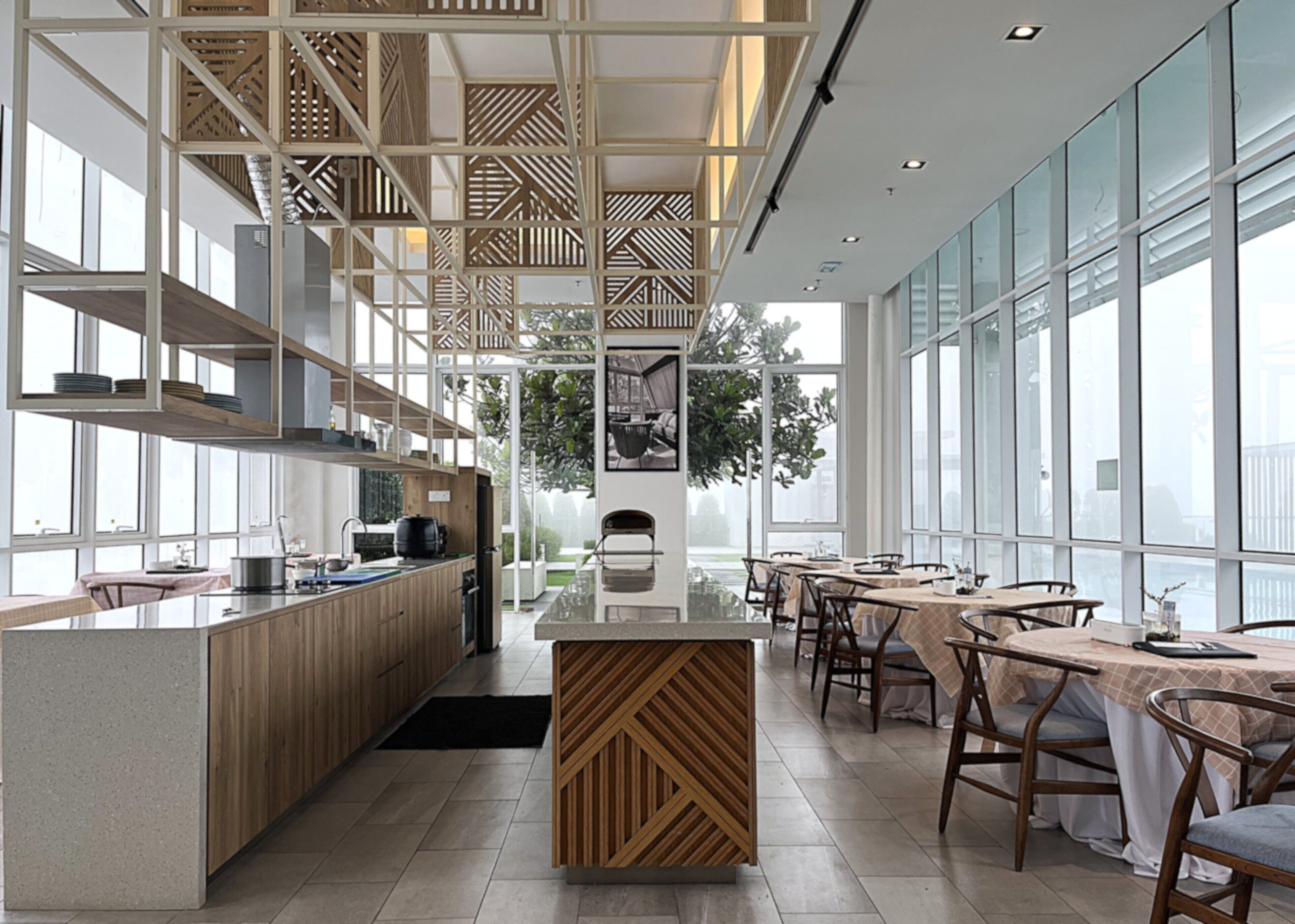 Una cocina moderna con armarios de madera, una isla central y un comedor con mesas y sillas.