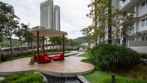 A modern outdoor area with a curved wooden deck, red seating, and a small water feature. - Swiss-Garden Hotel & Residences, Genting Highlands (Genting Highlands)
