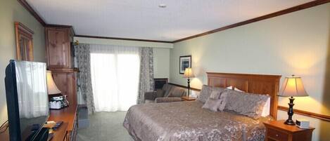 A hotel room with a bed, bedside lamps, a desk with a television, and a window with curtains.