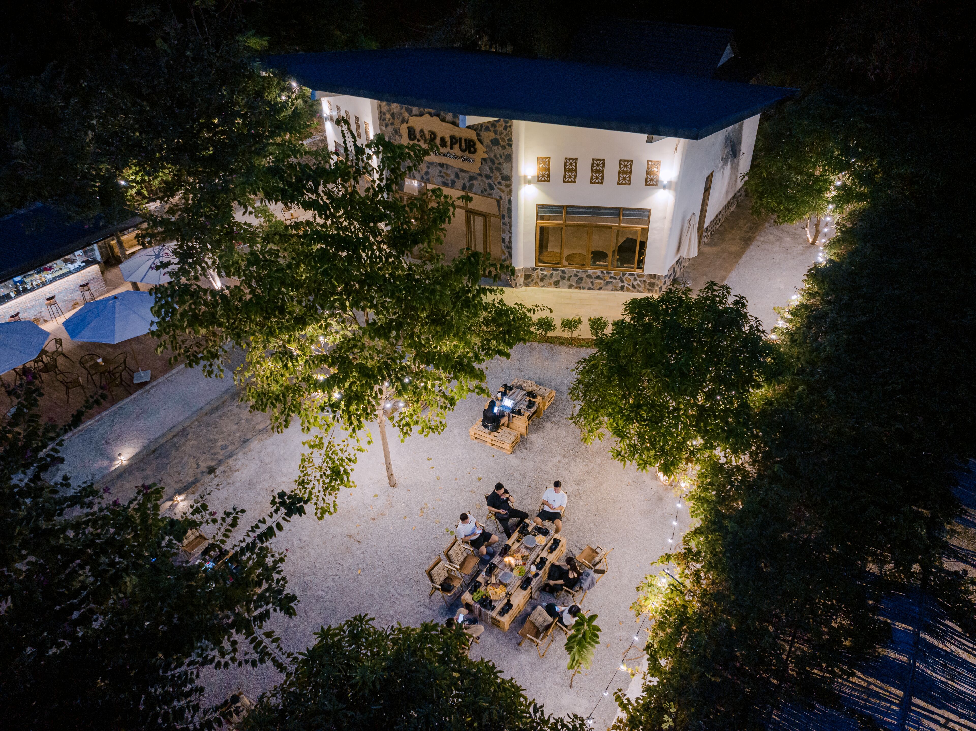 Eine Dachterrasse mit Bar und Pub, inklusive Außenbestuhlung und einer steinernen Fassade.