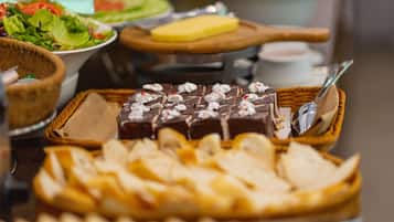 Un buffet proposant une variété de plats, notamment un dessert au chocolat, du pain et une salade.