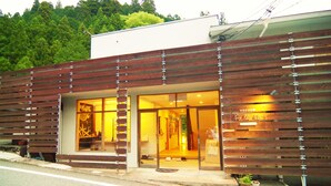 A modern building with large glass windows and wooden slats on the facade.