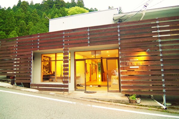 A modern building with large glass windows and wooden slats on the facade. - Misenkan (Tenkawa)