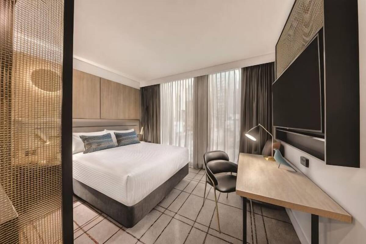 Een moderne hotelkamer met een groot bed, een bureau en een stoel.