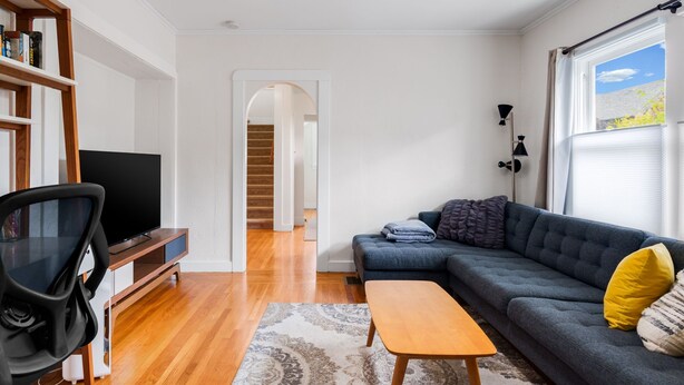 A living room with a sofa, a TV, a bookshelf, and a staircase leading to another room. - Quiet, Comfortable & Clean. Easy Access to SF, Berkeley, Contra Costa (Oakland)