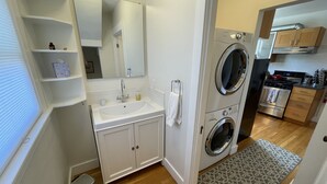 A compact kitchen with a sink, stove, and two washing machines. - Quiet, Comfortable & Clean. Easy Access to SF, Berkeley, Contra Costa (Oakland)