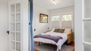 A bedroom with a bed, a window, a door, and a framed picture on the wall. - Quiet, Comfortable & Clean. Easy Access to SF, Berkeley, Contra Costa (Oakland)