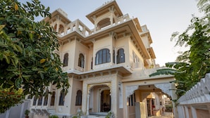 A traditional building with ornate architecture, multiple balconies, and a central entrance with steps.