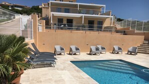Ein Swimmingpool mit Liegestühlen und einem Topfpflanzen.