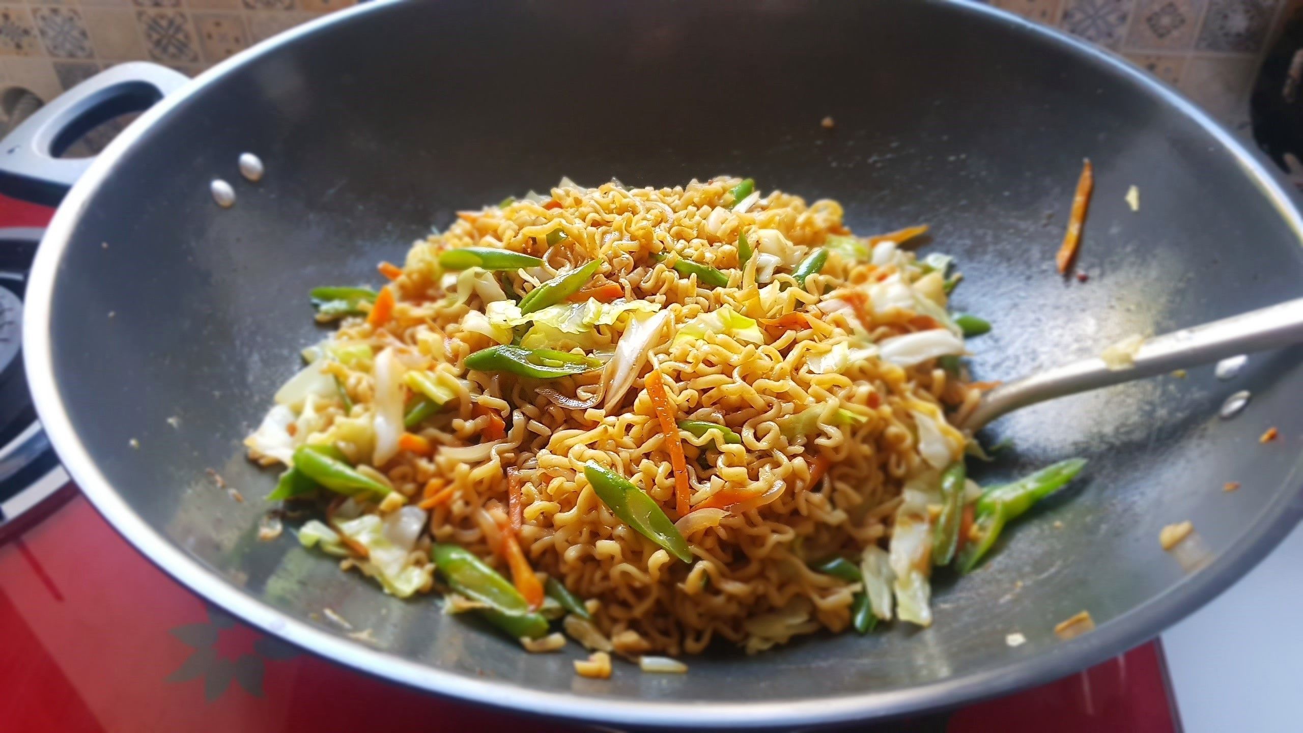 A wok filled with stir-fried noodles and vegetables.