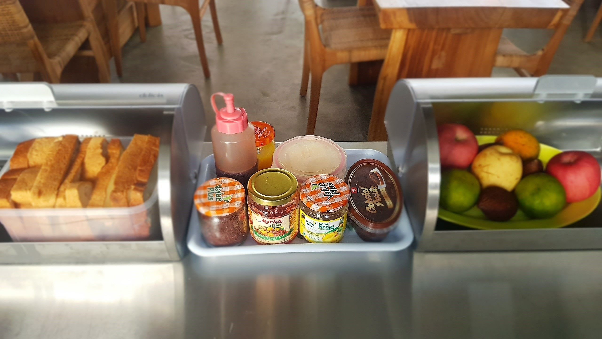 Un bufé con diversos alimentos, como pan, salsas y frutas.
