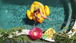 A pool with clear water, surrounded by greenery. - Bali Bobo Hostel (Jimbaran)