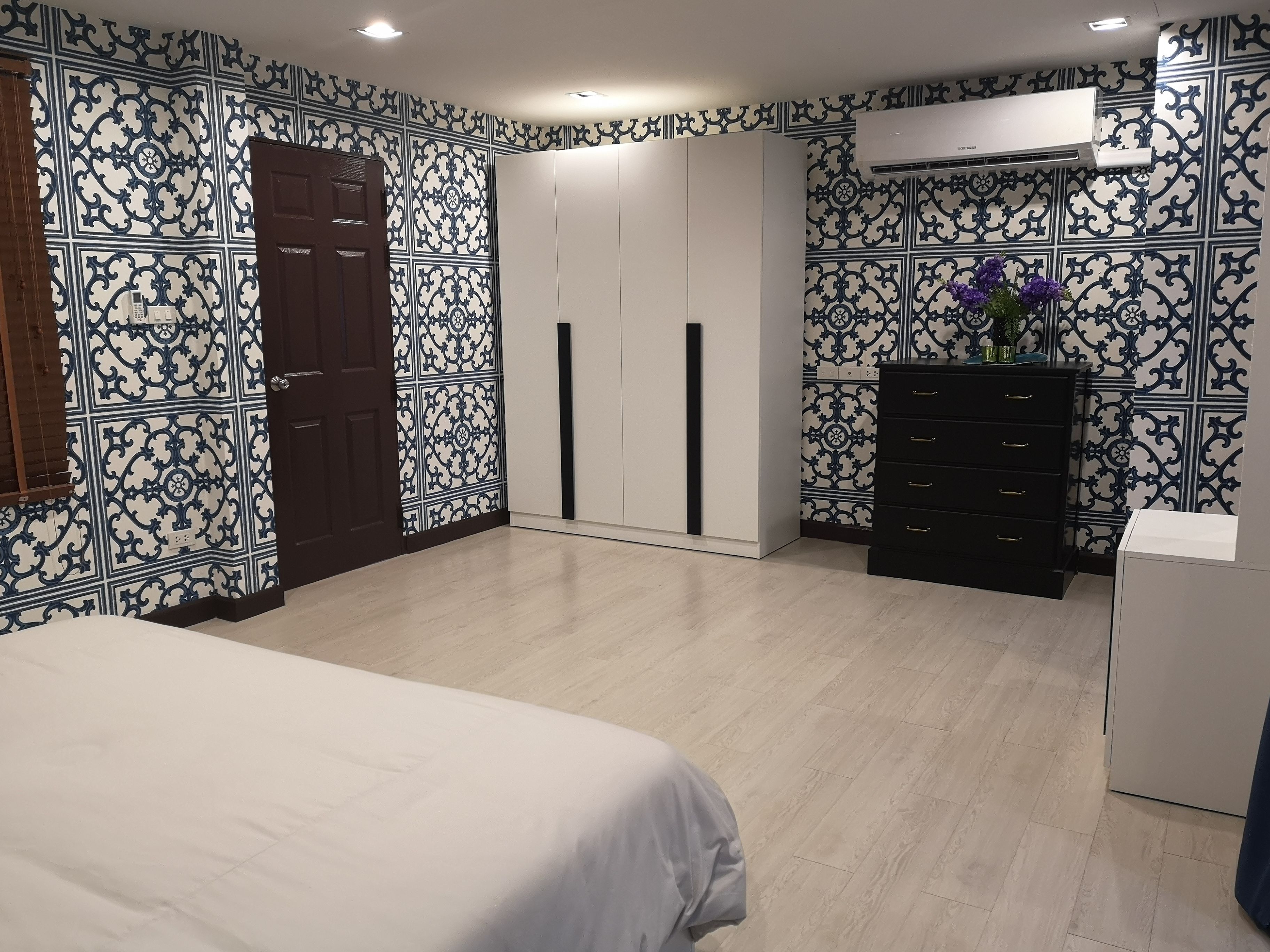 Une chambre à coucher comprenant un lit, une armoire, une commode et un appareil de climatisation.