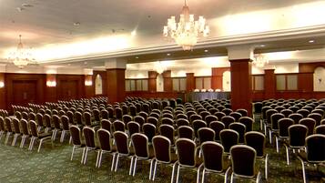 A large hall with rows of chairs and a carpeted floor.