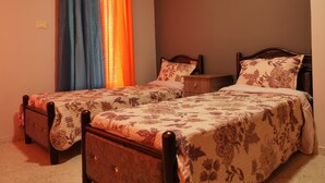 A bedroom with two single beds, a nightstand, and a window with curtains. - Visit Jerusalem & Bethlehem, Quite, Safe and free Secured parking.  (Jerusalem)