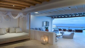 Una camera da letto con un letto, un comodino, una finestra e vista mare.