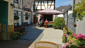 A narrow cobblestone alley with a wooden bench and potted plants. - Apartments Rheinblick-Koblenz (Neuendorf)