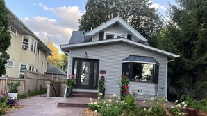 Ein Wohnhaus mit Veranda, kleinem Garten und Holzzaun.