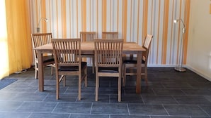 Un comedor con papel tapiz a rayas, una mesa de madera y sillas.